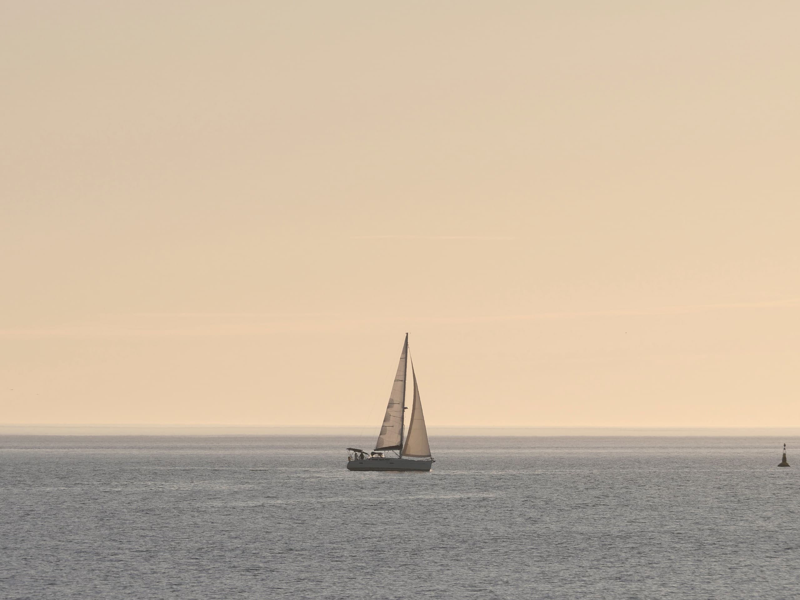 Segelboot auf ruhiger See unter weitem Himmel